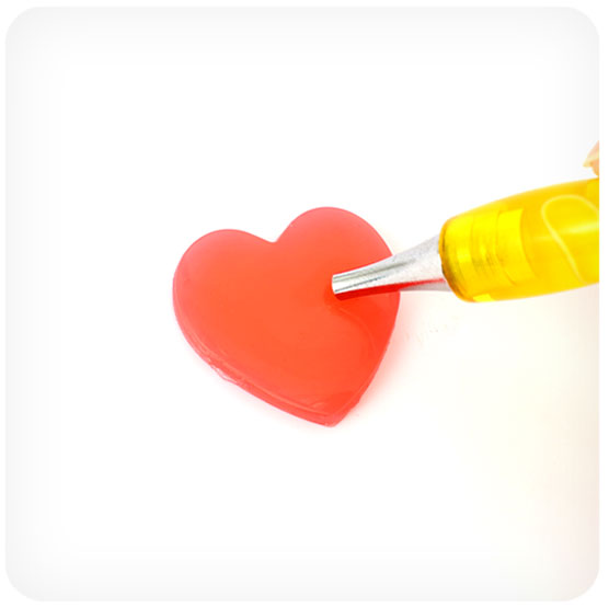 Step 2 of how to do diamond painting: placing the diamond painting pen into the wax block to pick up wax for drilling.